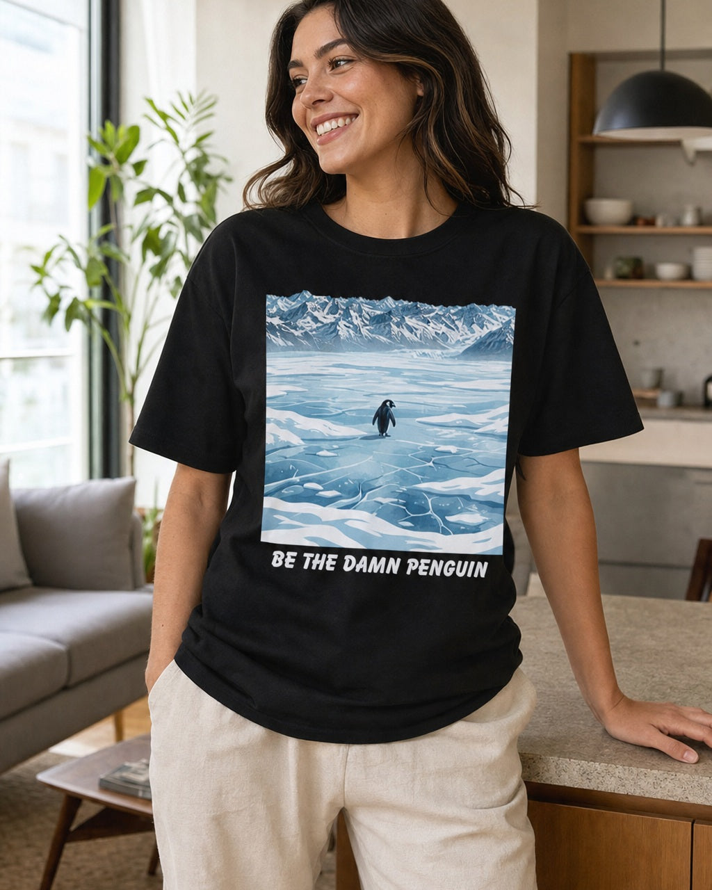 Be the Damn Penguin black graphic T-shirt styled in a casual home setting