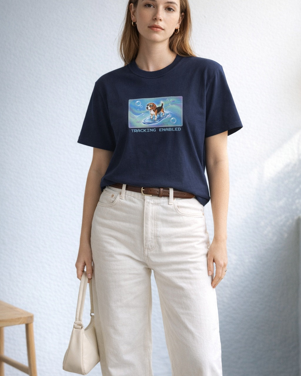 O's Tees Tracking Enabled Beagle Frutiger Aero Dogs graphic tee lifestyle image — Navy shirt, female shot 01, ecru barrel tan suede