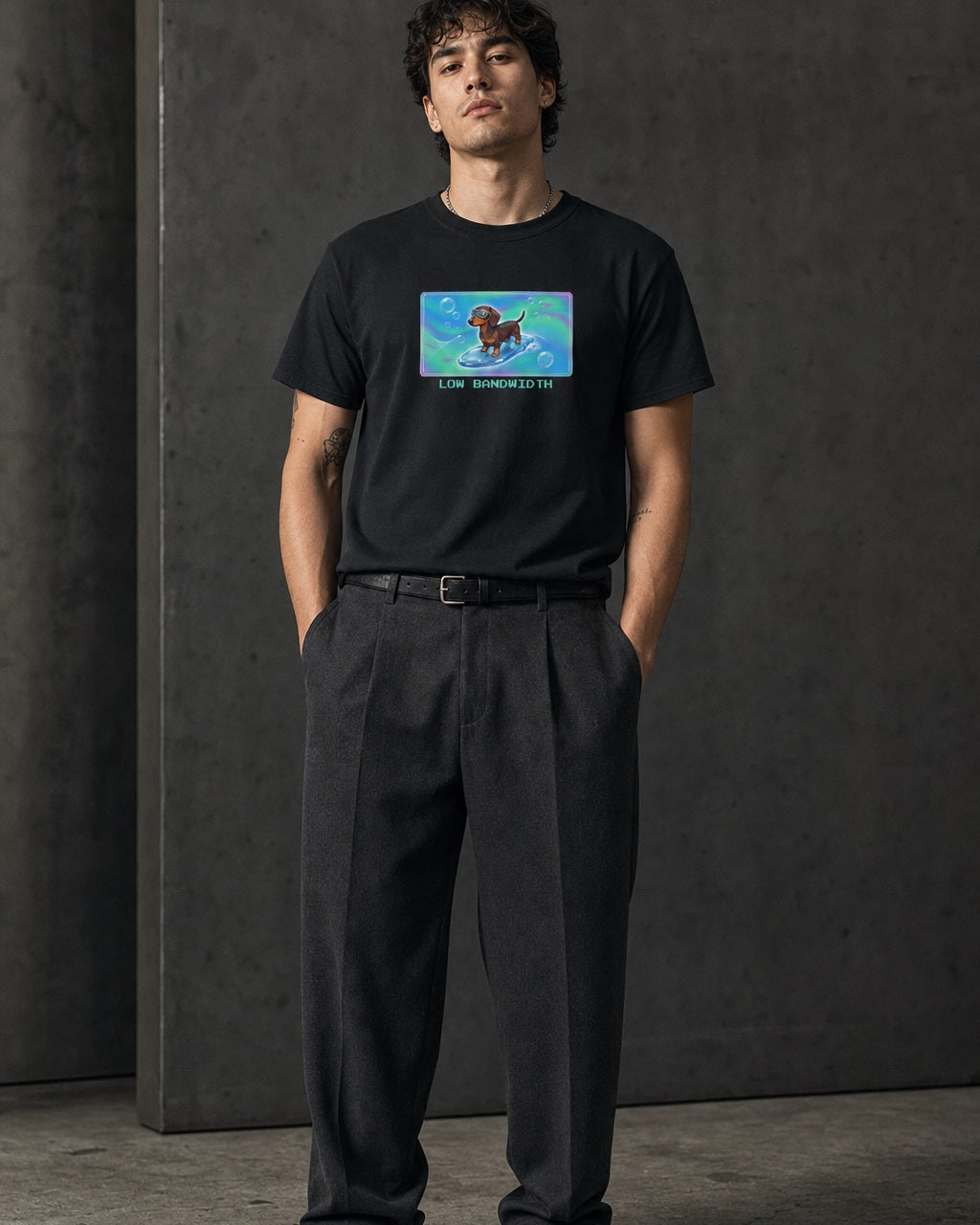 O's Tees Low Bandwidth Dachshund Frutiger Aero Dogs graphic tee lifestyle image — Black shirt, male shot 01, charcoal pleated trouser