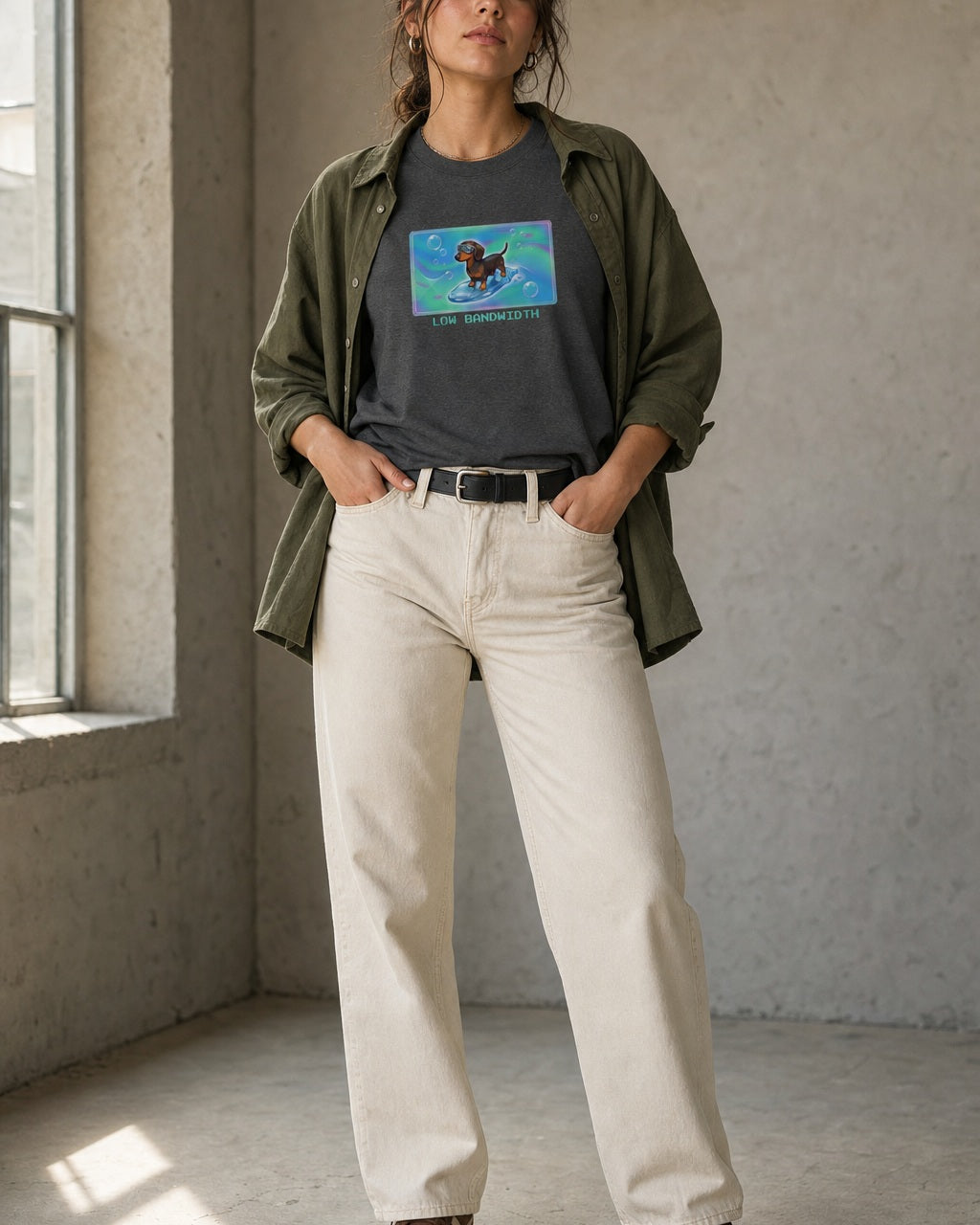 O's Tees Low Bandwidth Dachshund Frutiger Aero Dogs graphic tee lifestyle image — Dark Heather shirt, female shot 01, ecru denim olive overshirt
