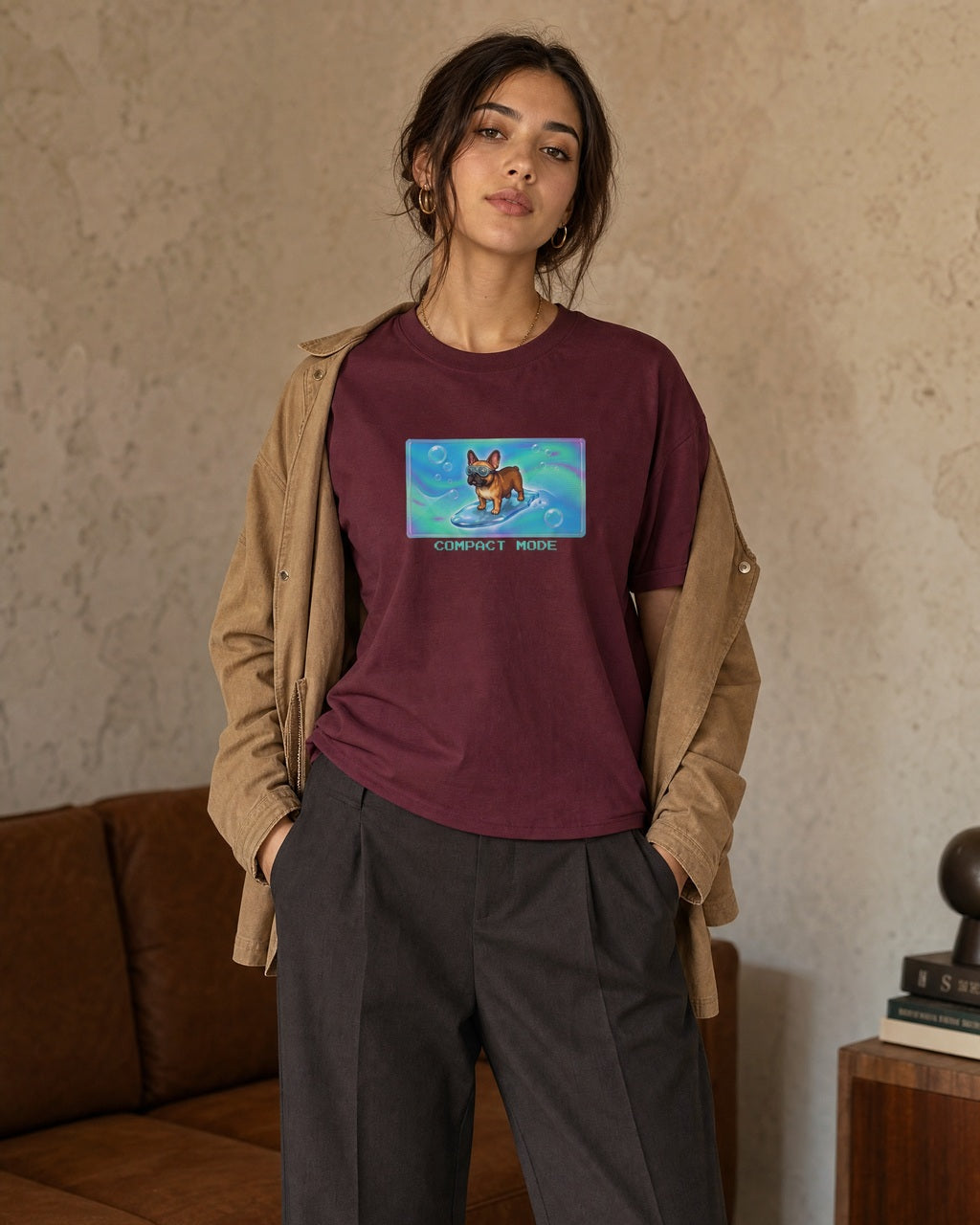 O's Tees Compact Mode French Bulldog Frutiger Aero Dogs graphic tee lifestyle image — Maroon shirt, female shot 02, charcoal trouser camel