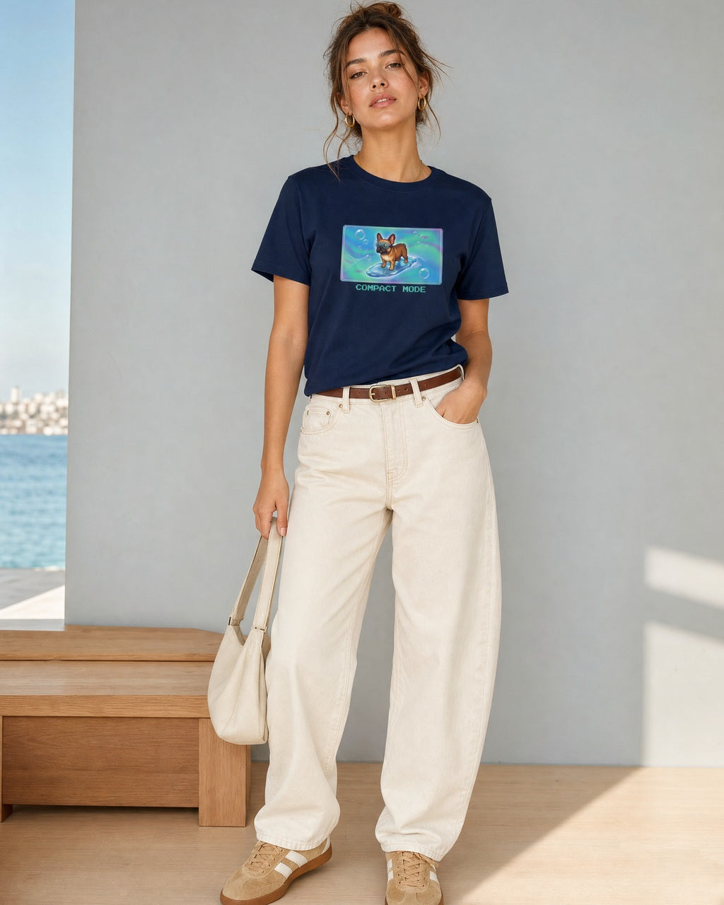 O's Tees Compact Mode French Bulldog Frutiger Aero Dogs graphic tee lifestyle image — Navy shirt, female shot 01, ecru barrel tan suede
