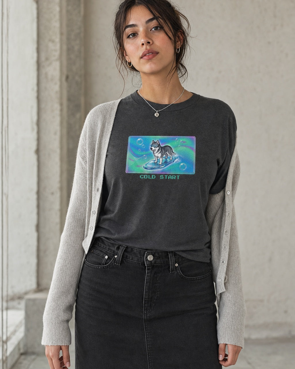 O's Tees Cold Start Husky Frutiger Aero Dogs graphic tee lifestyle image — Dark Heather shirt, female shot 02, washed black column skirt